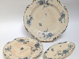 three pieces of blue and white plates with blue flowers on them