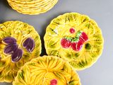 des assiettes jaunes et violettes ornées de fleurs, posées sur une table