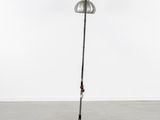a metal floor lamp with a metal base and a metal shade