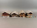 Plusieurs maisons miniatures sont alignées les unes à côté des autres sur une surface grise