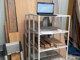 a laptop sitting on a shelf next to a pile of wood