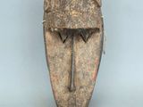 gros plan d'un masque en bois sur une surface blanche