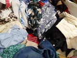 a pile of clothes that is on a bed