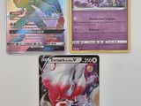 trois cartes Pokémon différentes posées sur une table avec un fond blanc