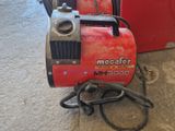 une machine rouge posée par terre à côté d'une boîte rouge