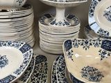 a lot of blue and white plates and bowls on the table