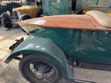 a green car with a surfboard on the back of it