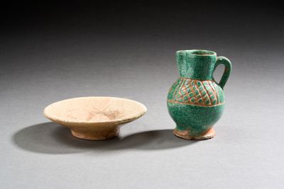 un vase vert posé à côté d'un petit bol sur une table