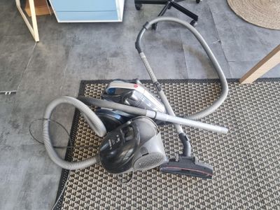 un aspirateur posé par terre à côté d'un tapis