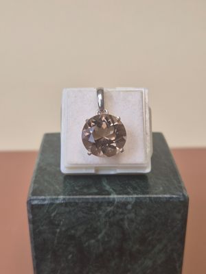 sterling silver pendant with a brown diamond on a marble block