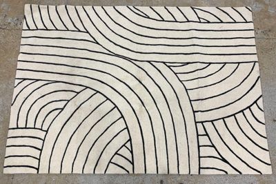 un tapis noir et blanc posé sur le sol en béton