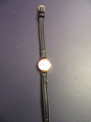 a close up of a wrist watch on a black surface