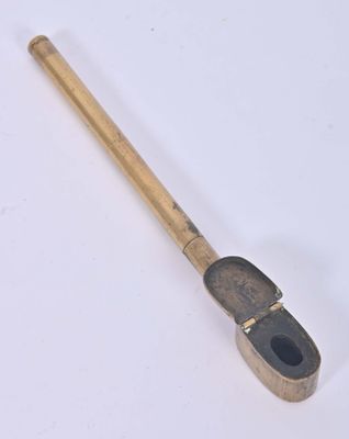an old metal pipe with a wooden handle sitting on top of a white surface