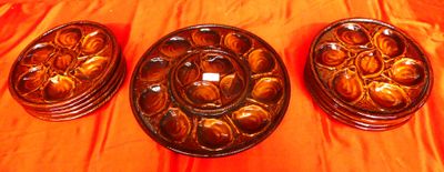 trois assiettes marron posées sur une nappe orange, sur une table
