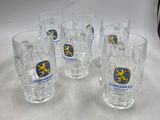 four shot glasses with a blue and yellow emblem on them