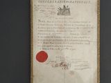 an old document with a red wax seal on it sitting on a table