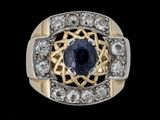 un gros plan d'une bague ornée d'un saphir bleu entouré de diamants