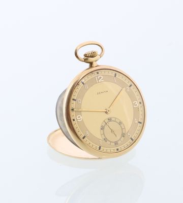 une montre de poche en or posée sur une table en verre