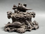 a statue of a bird sitting on top of a tree stump
