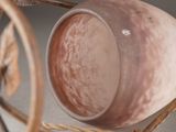a close up of a vase on a stand on a table