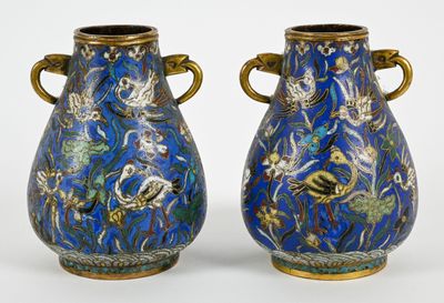 une paire de vases bleus avec des anses dorées sur fond blanc