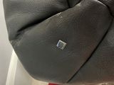 someone is holding a black purse with a silver button on it