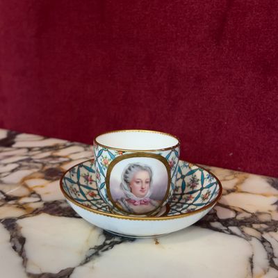 une tasse et une soucoupe sur lesquelles est représentée une femme