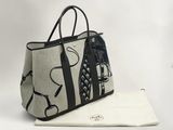 un sac noir et blanc posé sur une serviette blanche