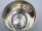 a silver bowl on a table with a white background