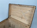 an old suitcase with a clock in it sitting on the floor