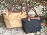 two bags sitting on the ground next to each other