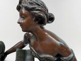 a bronze statue of a woman reading a book