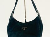 Sac à bandoulière Prada en cuir noir présenté sur fond blanc