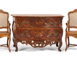 two chairs and a chest of drawers with carvings on the sides