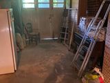 an image of a garage with a refrigerator and ladders