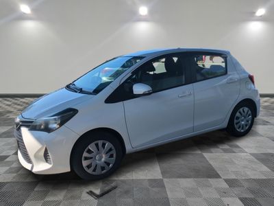 une Toyota Yaris blanche garée sur un sol en carrelage à damier
