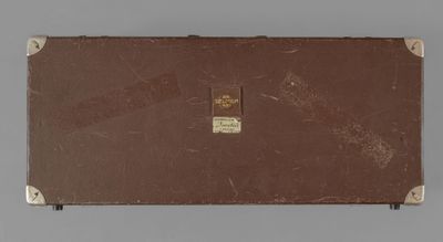 an old suitcase sitting on top of a table with a tag on it