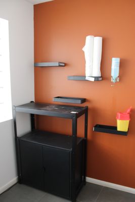 un bureau avec une étagère et une chaise dans un coin