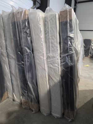 many mattresses wrapped up in plastic in a warehouse