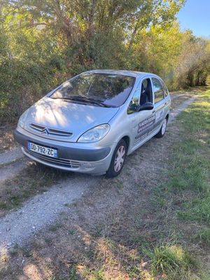 the car is parked on the side of the road near the trees