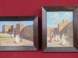two framed paintings of people walking down a street in front of a red wall