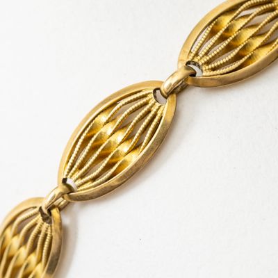 un gros plan d'un bracelet plaqué or sur un fond blanc
