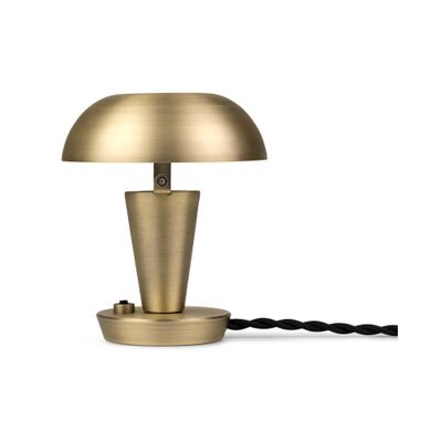 une lampe de table dorée avec un cordon noir sur fond blanc