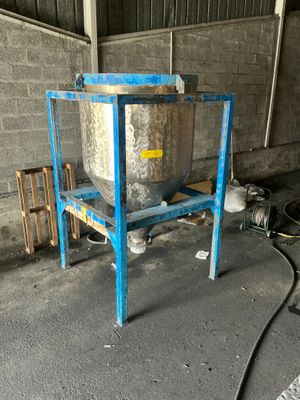 a metal tank sitting on a blue stand in a building