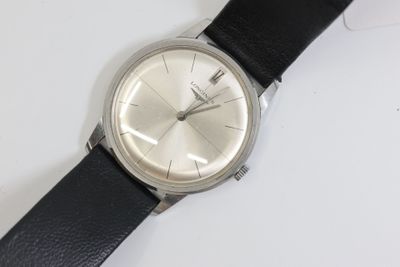 une montre posée sur une surface blanche