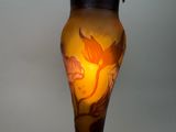 a glass vase with a bird on it sitting on a table