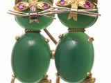 pair of green cat earrings with purple stones on them