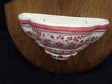 a red and white bowl sitting on a wooden stand