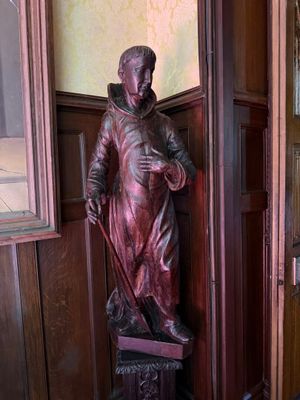 une statue représentant un homme tenant une canne dans une pièce