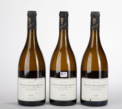 trois bouteilles de vin sont posées côte à côte sur une surface blanche